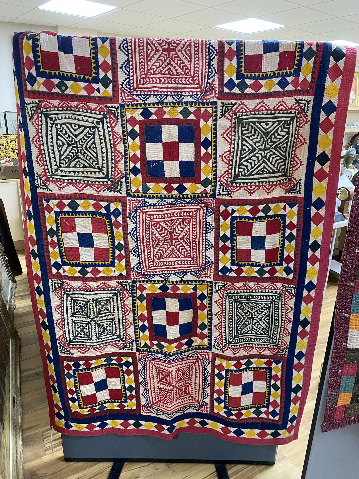 An Indian late 19th early 20th century quilt, worked with ornately designed multicoloured squares of patchwork, 122cm wide, 190cm long